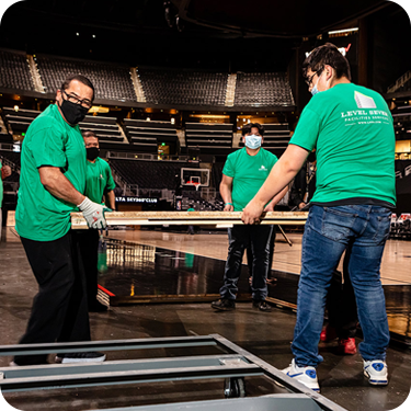 Photo of 4 Level Seven workers cleaning up at a stadium