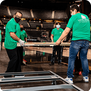 Photo of 4 Level Seven workers cleaning up at a stadium