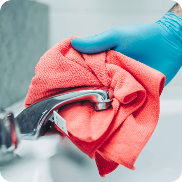 Photo of a hand holding a cloth under a faucet