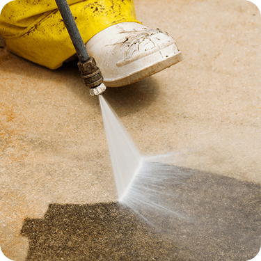 Close-up photo of pressure washer blasting concrete